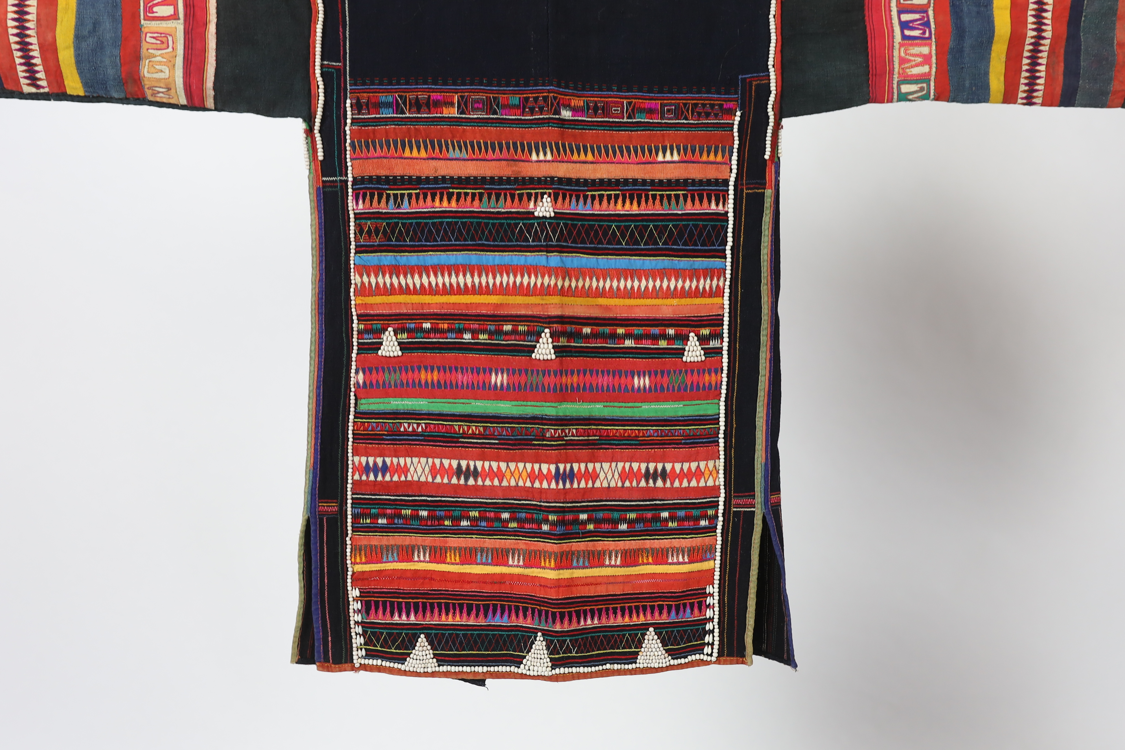 A Chiang Mai (Thailand) embroidered ladies three quarter length jacket, embroidered in hand dyed polychrome threads, (HKHA jacket) with beaded borders and spot design on a hand woven linen, 79cm long from neck to base